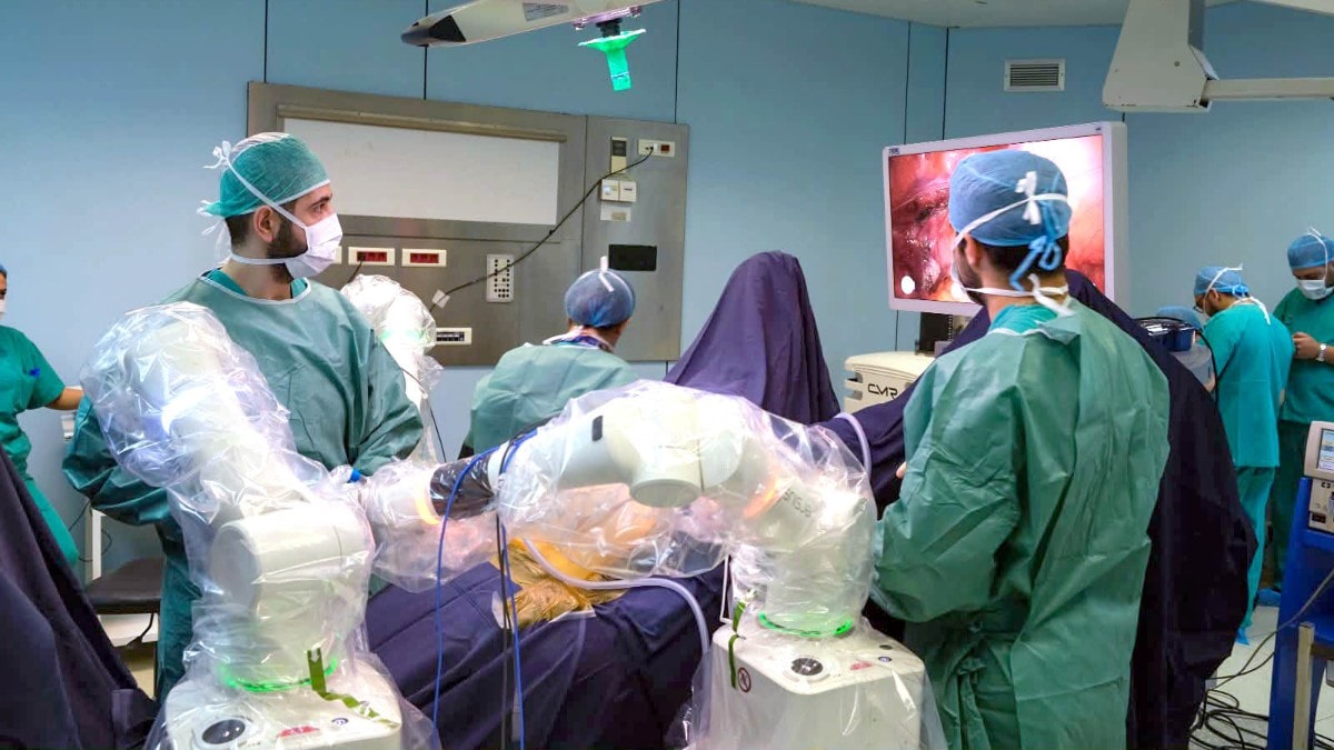 Medical team performing a gynecological surgery using an advanced surgical robot inside an operating room at Hôtel-Dieu France hospital.